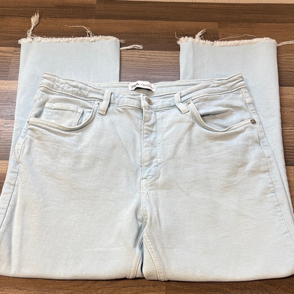 Zara brand light-wash denim jeans featuring a straight-leg cut and a raw, frayed